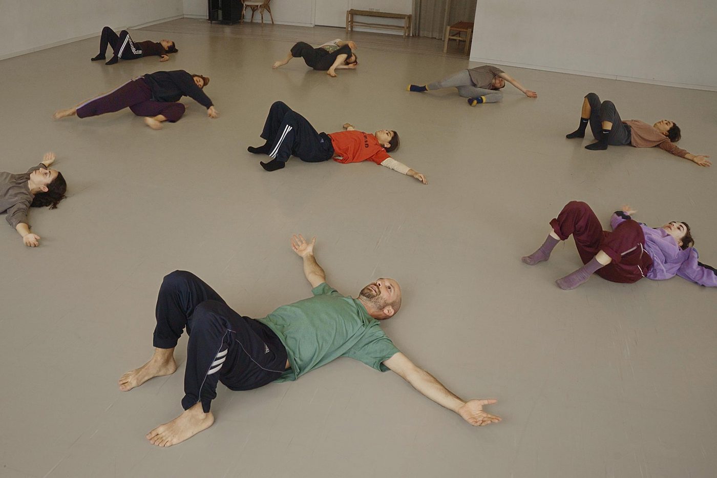 Tal and students lying on the studio floor during class